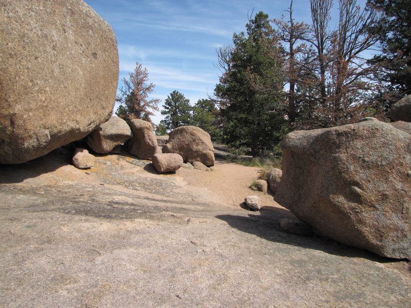 Trail heads to the right of the large boulder